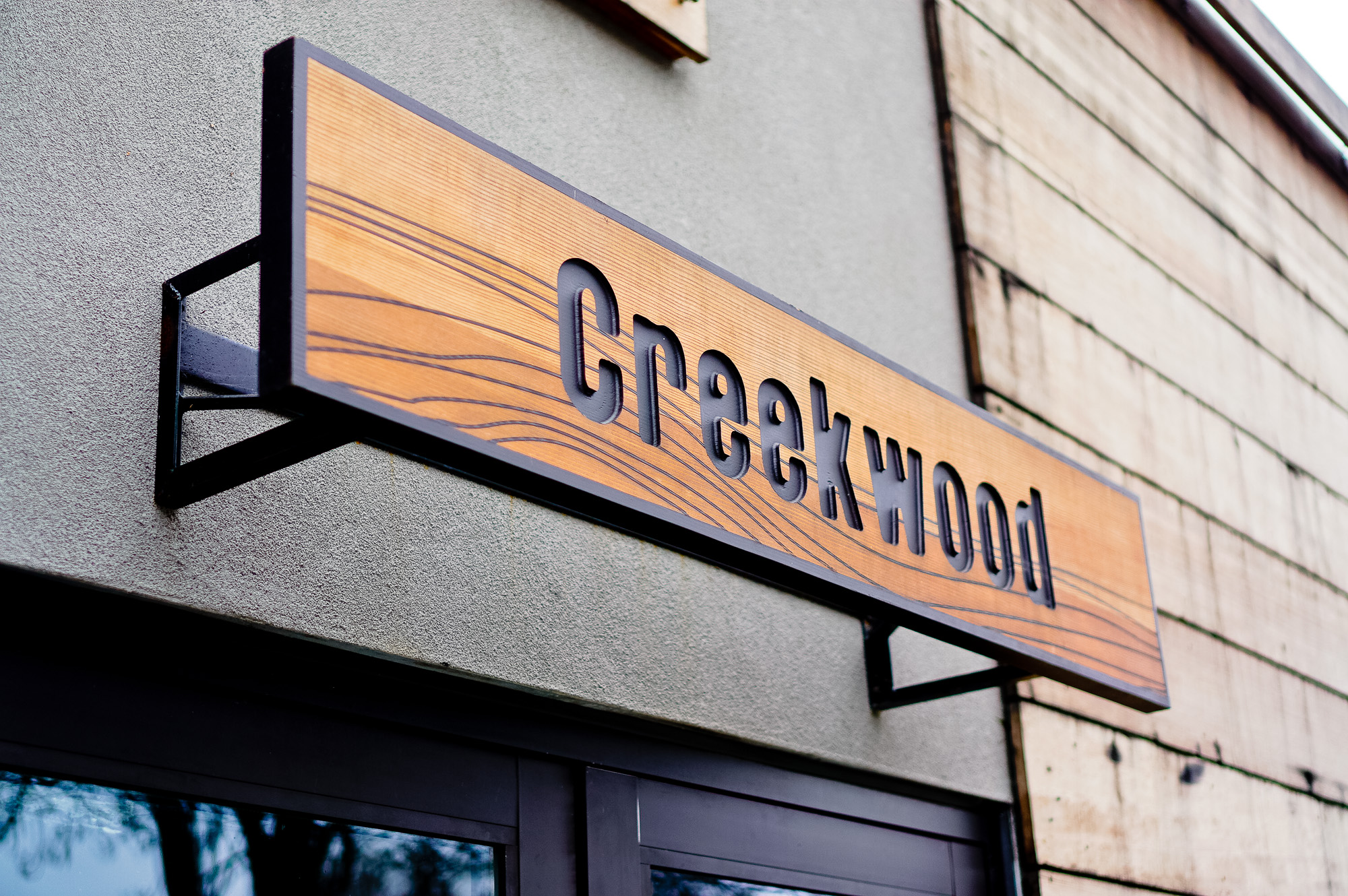 Engraved cedar wood sign on concrete walkl for Creekwood, a Californian-Italian restaurant in Berkeley, CA Engraved cedar wood sign on concrete walkl for Creekwood, a Californian-Italian restaurant in Berkeley, CA