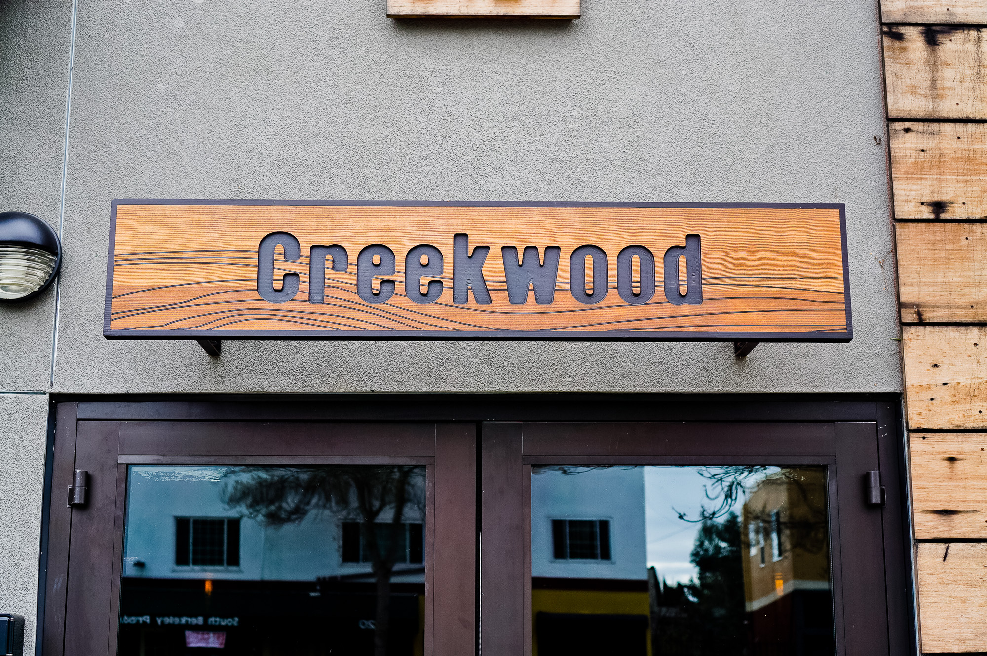 Engraved cedar wood sign on concrete walkl for Creekwood, a Californian-Italian restaurant in Berkeley, CA Engraved cedar wood sign on concrete walkl for Creekwood, a Californian-Italian restaurant in Berkeley, CA