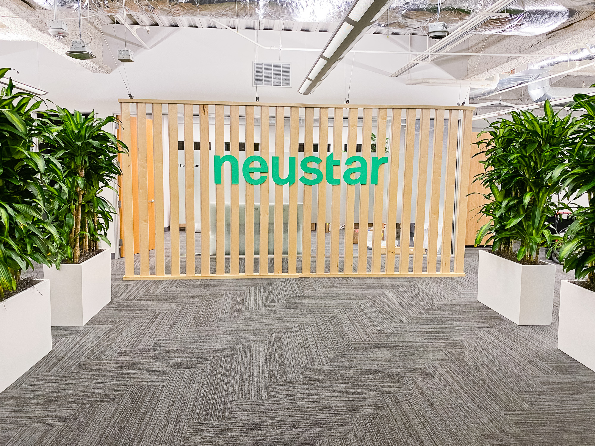 Wood slat dividing wall wiht green logo for lobby/reception desk area at the San Francisco office of Neustar, an American technology company that provides real-time information and analytics. Wood slat dividing wall wiht green logo for lobby/reception desk area at the San Francisco office of Neustar, an American technology company that provides real-time information and analytics.