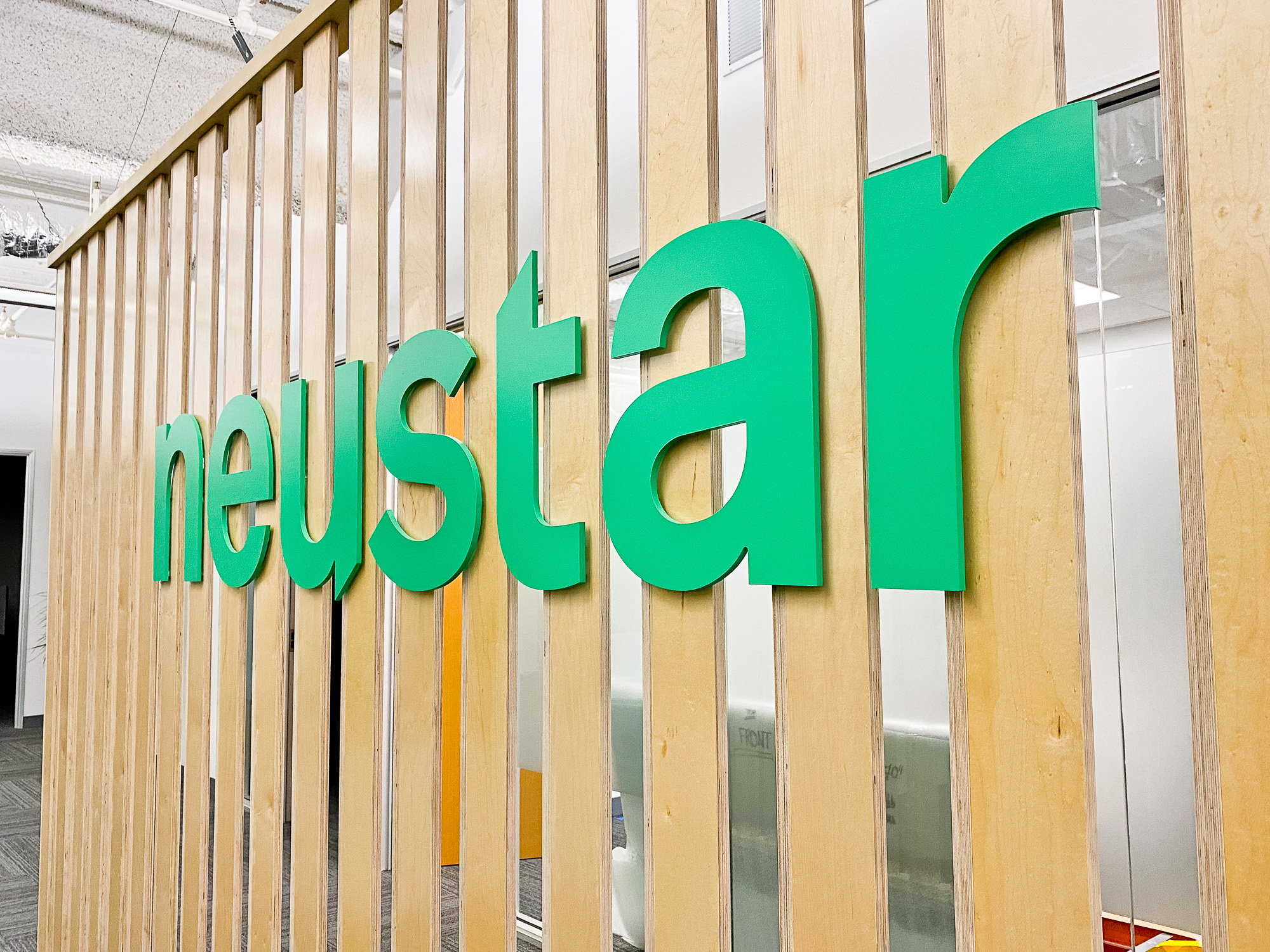 Wood slat dividing wall wiht green logo for lobby/reception desk area at the San Francisco office of Neustar, an American technology company that provides real-time information and analytics. Wood slat dividing wall wiht green logo for lobby/reception desk area at the San Francisco office of Neustar, an American technology company that provides real-time information and analytics.