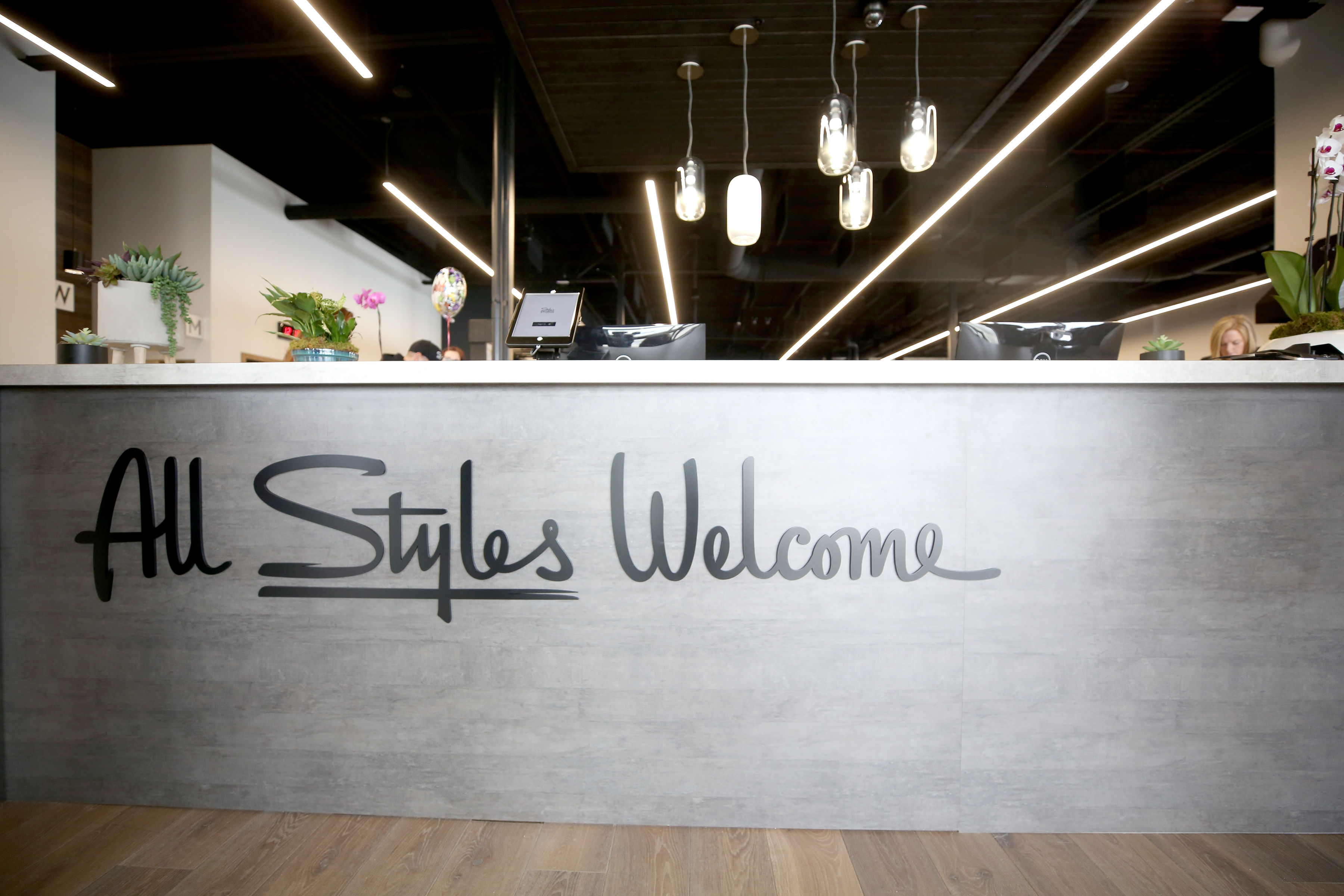 Black script front desk sign for the lobby at Styles Studios, a fitness club in Peoria, IL.