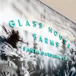 Teal letters on black and white photo mural for the retail display for Glass House Farms, a cannabis nursery in Santa Barbara, CA.