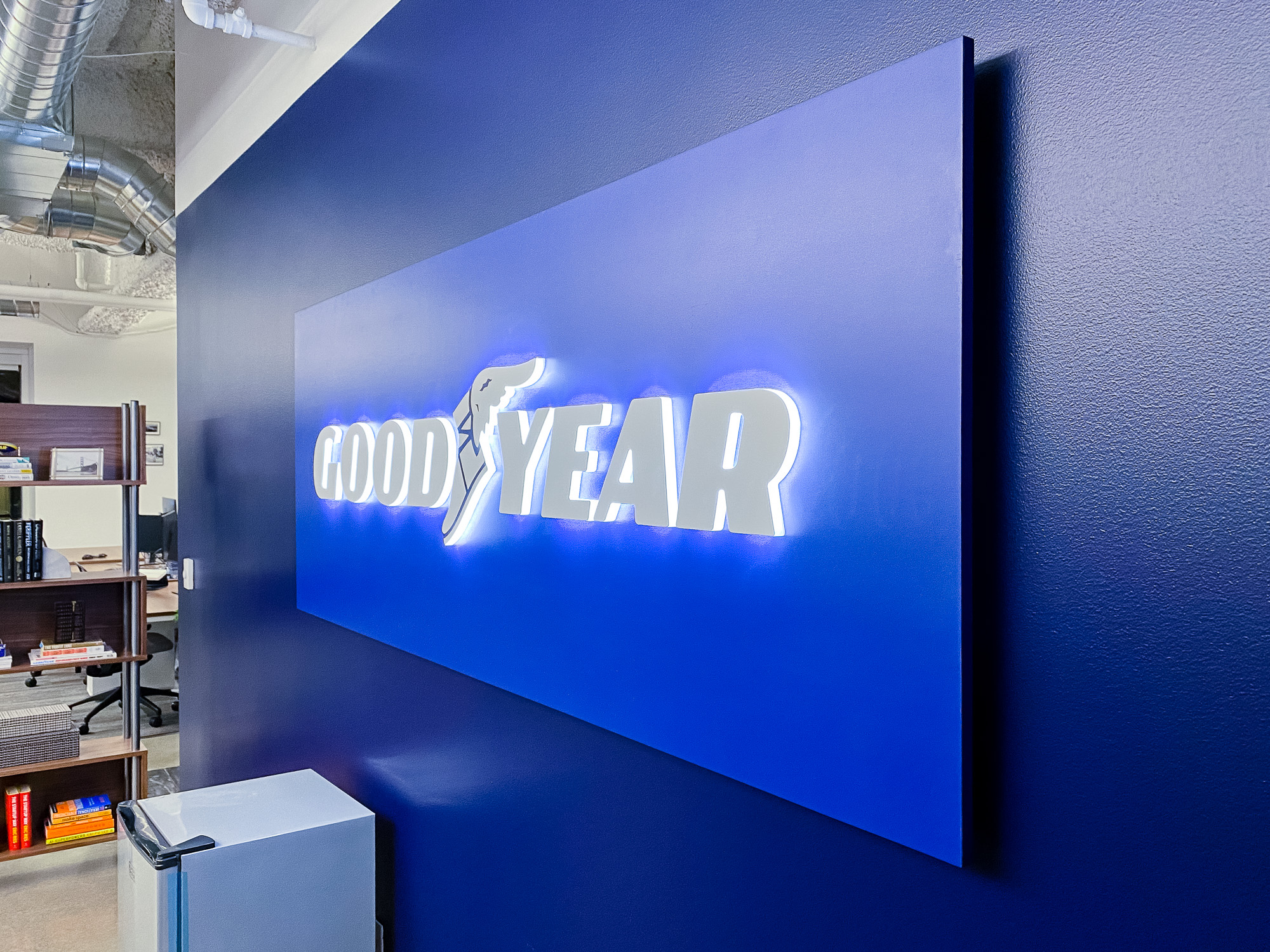 Illuminated, blue, edge-lit lobby sign behind reception desk for the San Francisco office of Goodyear, a tire manufacturer. Illuminated, blue, edge-lit lobby sign behind reception desk for the San Francisco office of Goodyear, a tire manufacturer.
