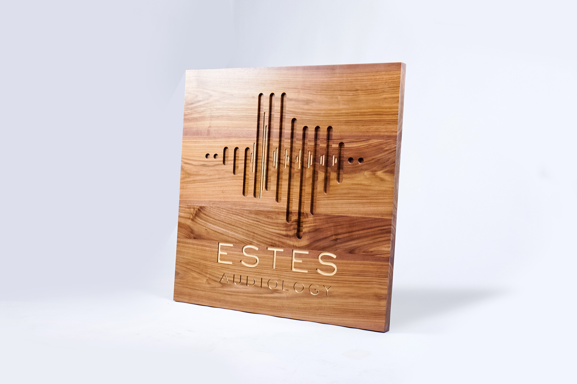 Solid walnut sign with engraved and inlaid logo for Estes Audiology, one of the largest independent hearing device practices in the Texas Hill Country.
