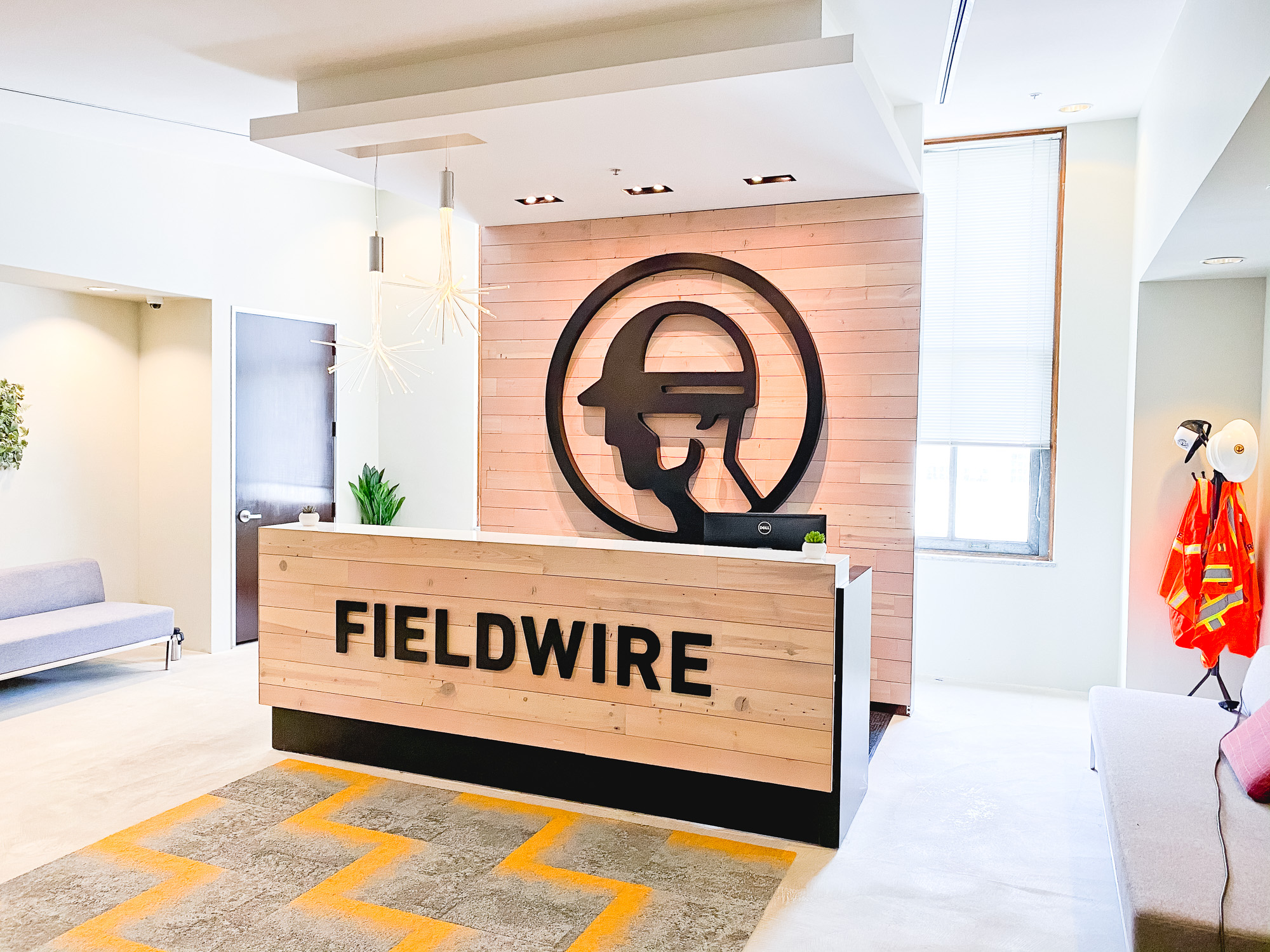 Dimensional black reception wall and desk sign for the San Francisco lobby of Fieldwire, a company creating a construction field management platform designed for the jobsite.