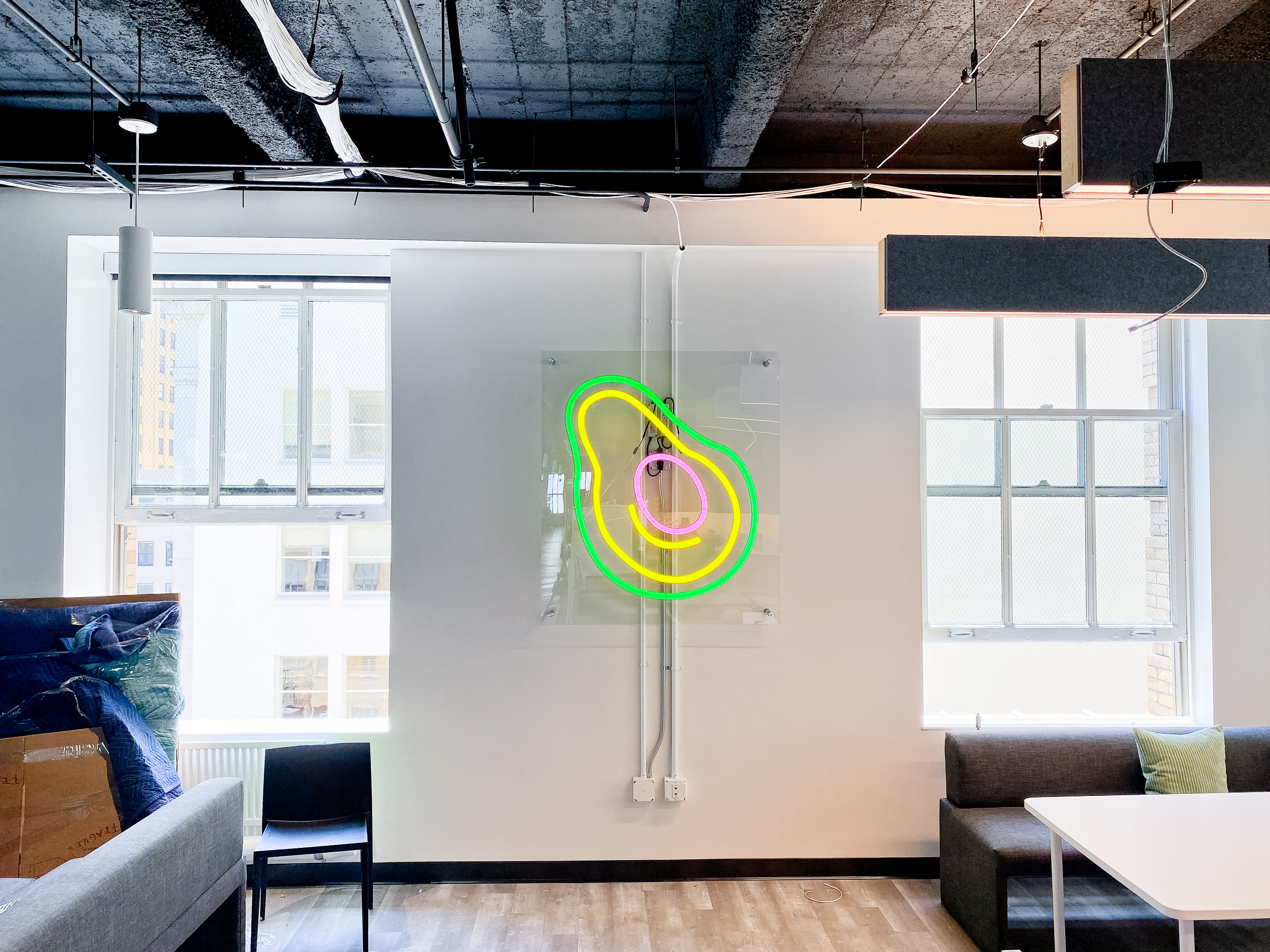 Neon avocado sign with clear acrylic backer on white wall for the San Francisco office of Meltwater, a software as a service company that develops and markets media monitoring and business intelligence software. Neon avocado sign with clear acrylic backer on white wall for the San Francisco office of Meltwater, a software as a service company that develops and markets media monitoring and business intelligence software.