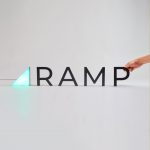 Illuminated, freestanding green triangle and black letters for Ramp, a technology company building the next generation corporate card to save businesses money.