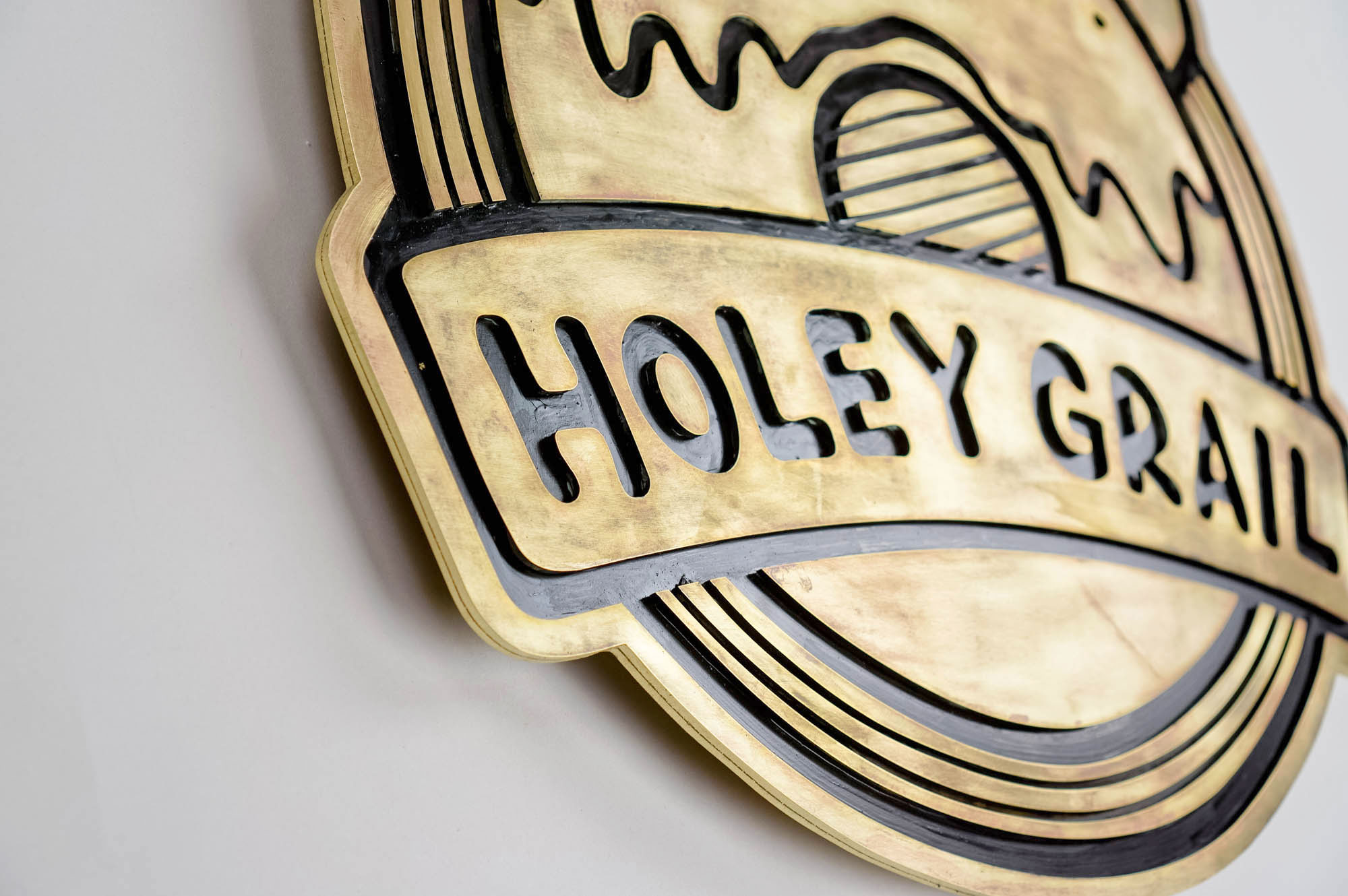 Patinated, retro brass sign for Holey Grail, a donut shop based in Hawaii. Patinated, retro brass sign for Holey Grail, a donut shop based in Hawaii.