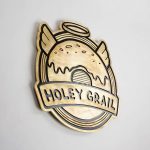 Patinated, retro brass sign for Holey Grail, a donut shop based in Hawaii.