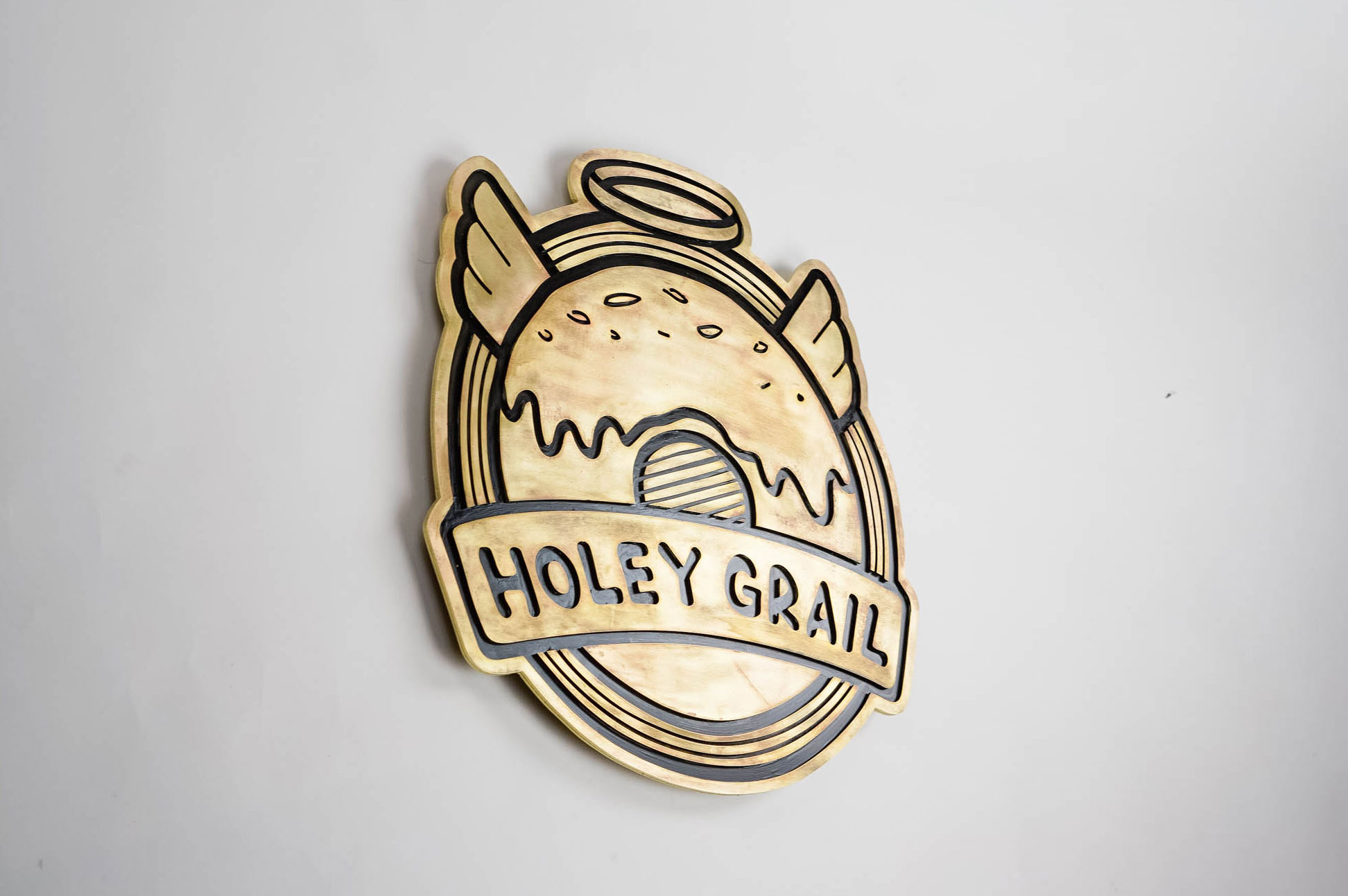 Patinated, retro brass sign for Holey Grail, a donut shop based in Hawaii. Patinated, retro brass sign for Holey Grail, a donut shop based in Hawaii.