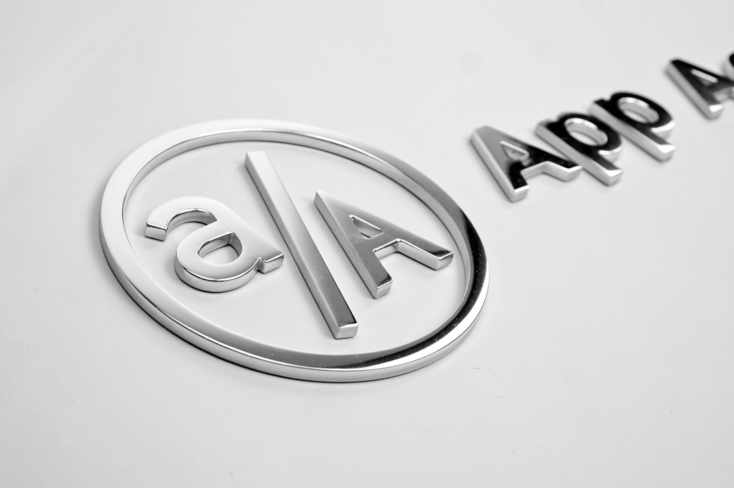 Polished metal sign for granite column for the New York office of App Academy, a software training institute.