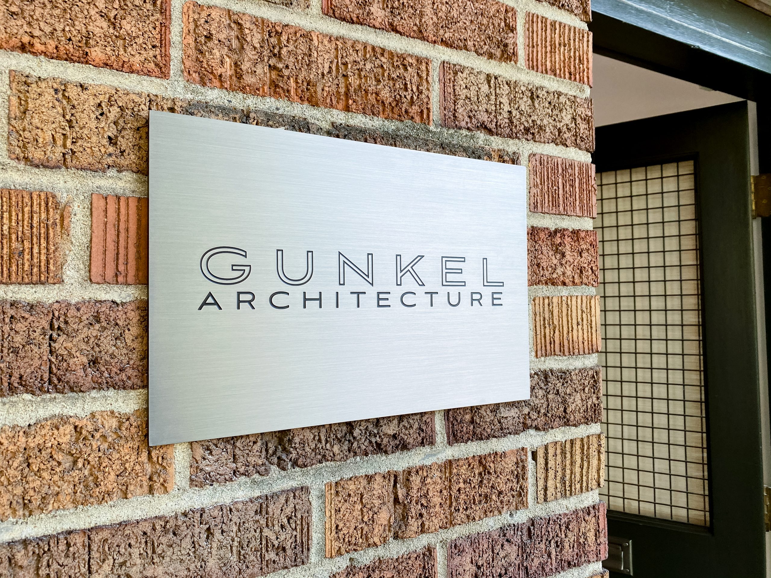 Engraved and paint filled metal sign for Gunkel Architecture, a studio focused on sustainable, community-focused architecture.