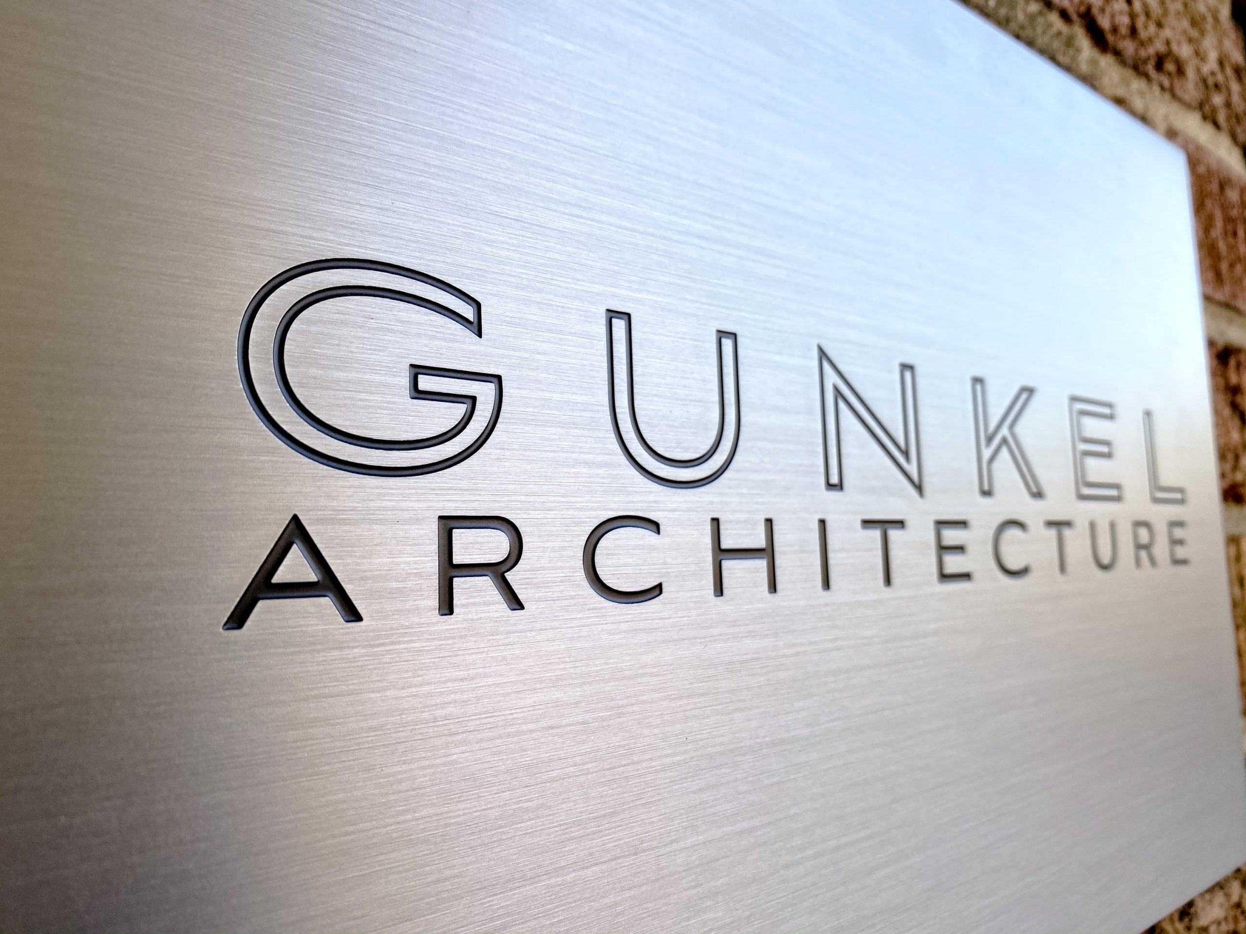Engraved and paint filled metal sign for Gunkel Architecture, a studio focused on sustainable, community-focused architecture.