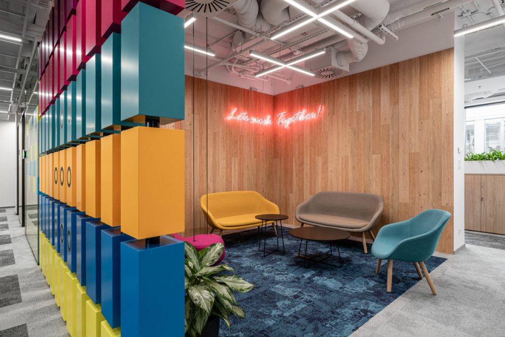 Red neon sign on wood wall with modern seating at the AkzoNobel office in Warsaw, Poland. (Photo: Fotomohito)