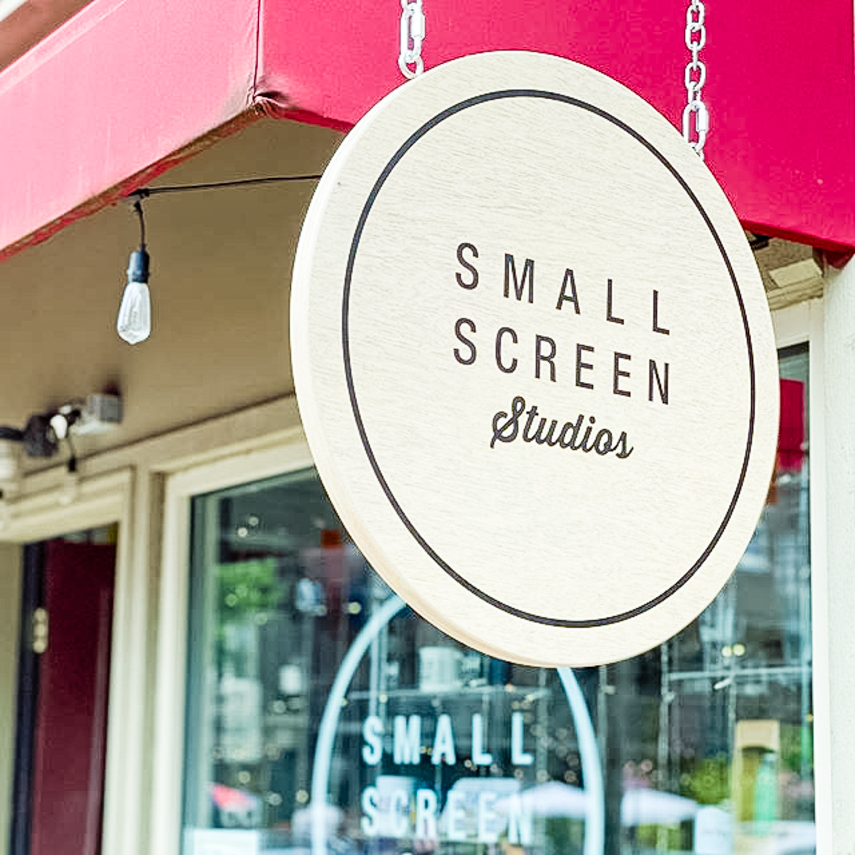 small-screen-studios-hanging Wood hanging blade sign with black artwork for the storefront of Small Screen Studios, a shop in Cleveland, OH.