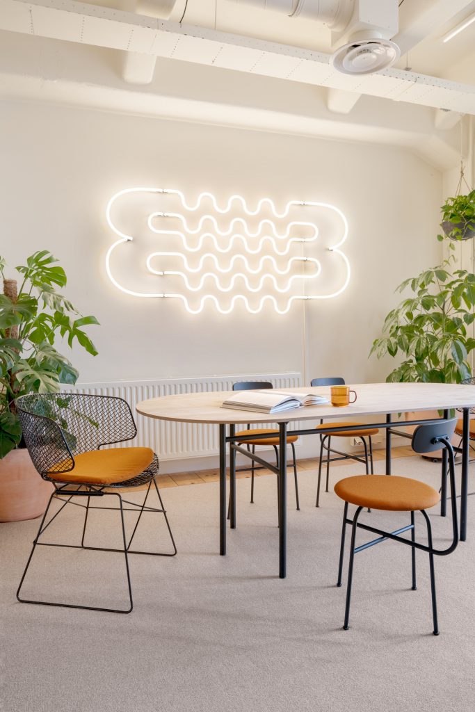 White neon squiggle in modern office conference room.