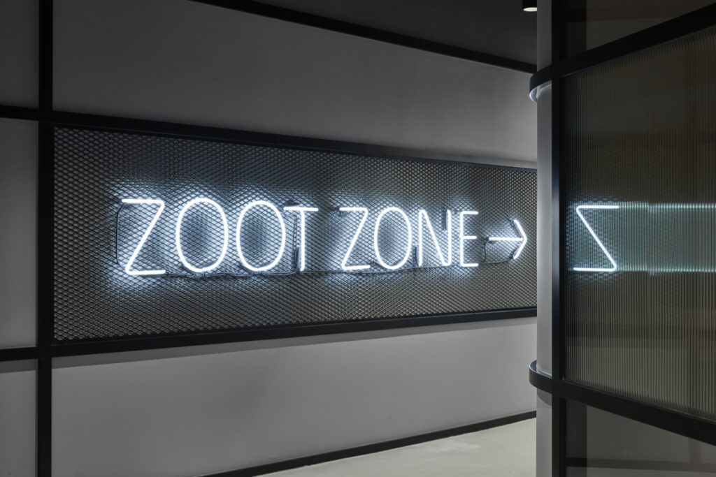 White neon Zoot Zone sign on metal cage/grid for the office of Deswik in Fortitude Valley, Australia. (Photo: Cieran Murphy)