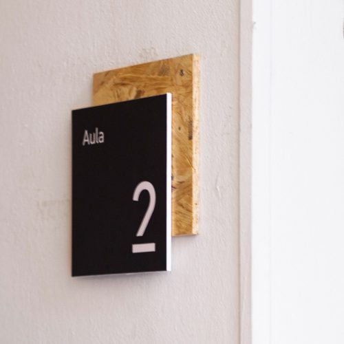 Black room sign with cork backer and white text for ISIA in Firenze, Italy.