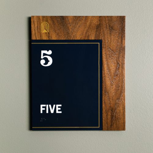 Retro style black and walnut room sign with white and brass details, designed by Studio Mast for The Ramble Hotel, a French Salon inspired hotel in Denver’s fastest growing neighborhood.