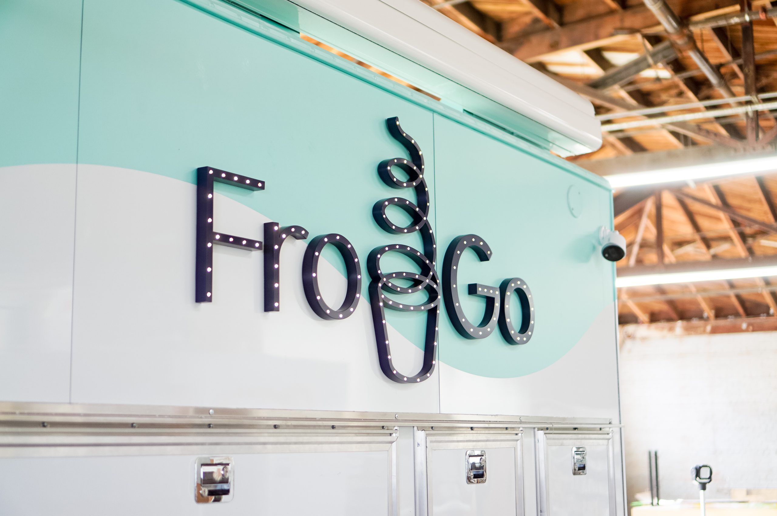 Illuminated, marquee-style sign on food truck for FroGo, a customizable, self-serve, dairy-free, frozen yogurt truck.