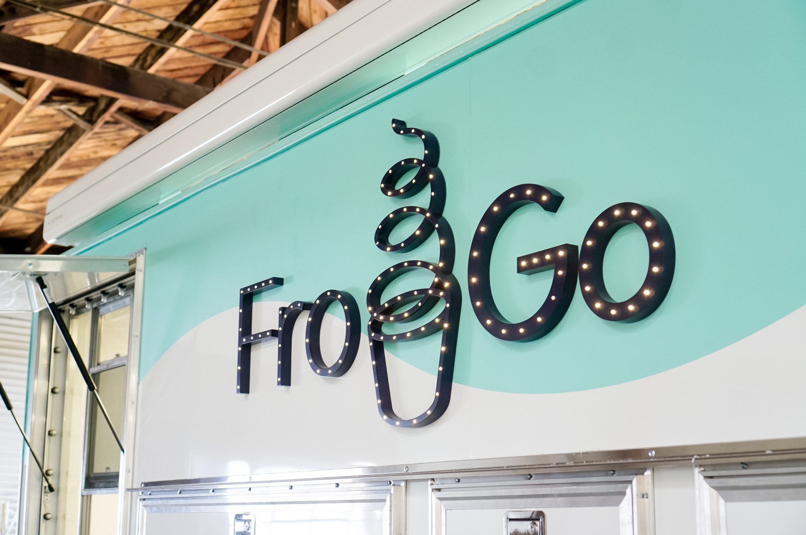 Illuminated, marquee-style sign on food truck for FroGo, a customizable, self-serve, dairy-free, frozen yogurt truck.
