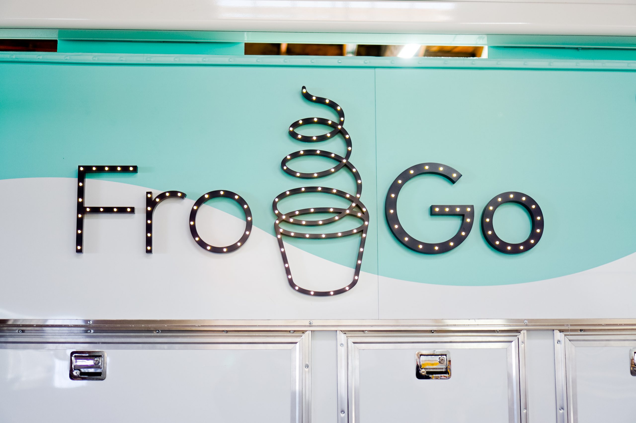 Illuminated, marquee-style sign on food truck for FroGo, a customizable, self-serve, dairy-free, frozen yogurt truck.