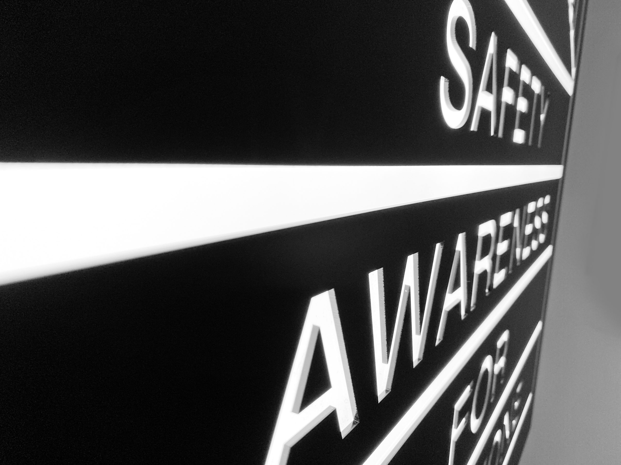 Illuminated, black-and-white, poster-style lightbox sign for the elevator vestibule of SAFE, an organization that partners with the San Francisco Police Department to educate and empower San Franciscans to build safer neighborhoods.