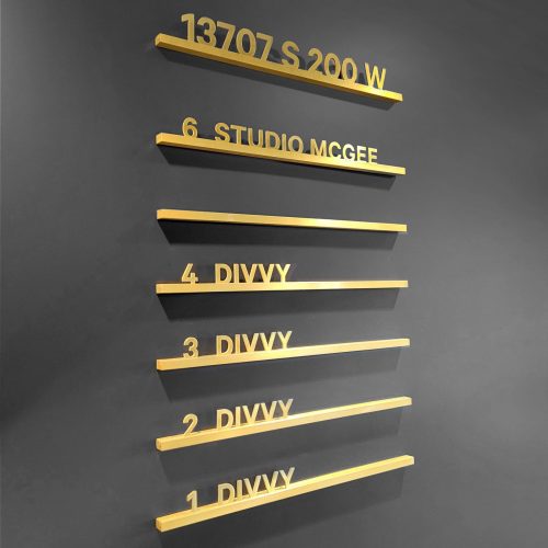 Changeable brass directory sign on grey painted lobby/elevator bank wall for Divvy, a software company based in Draper, Utah.