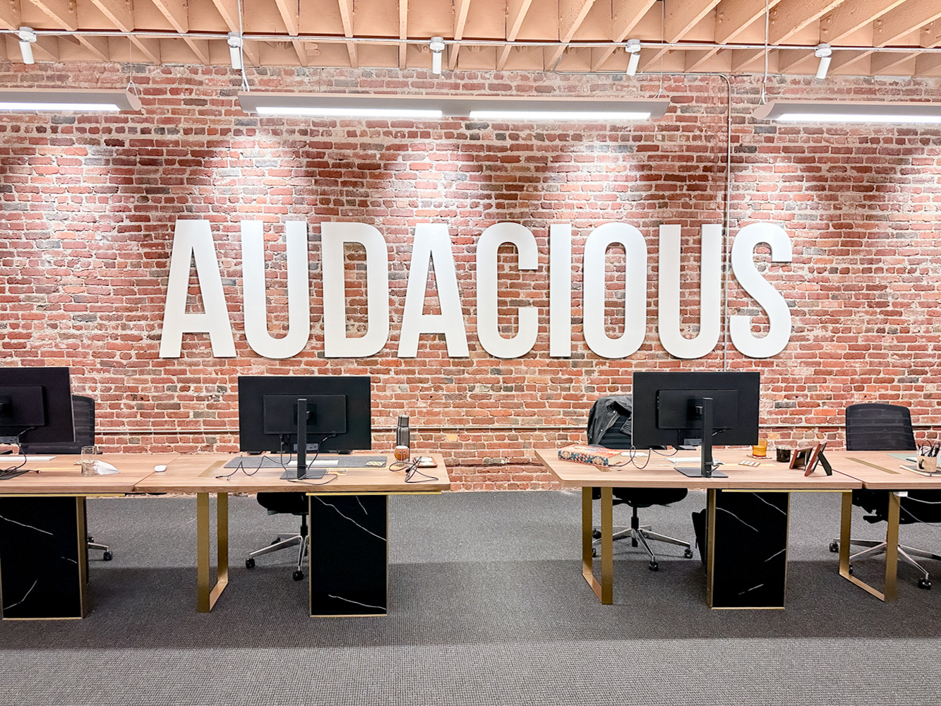 audacious-white-sign-brick-wall