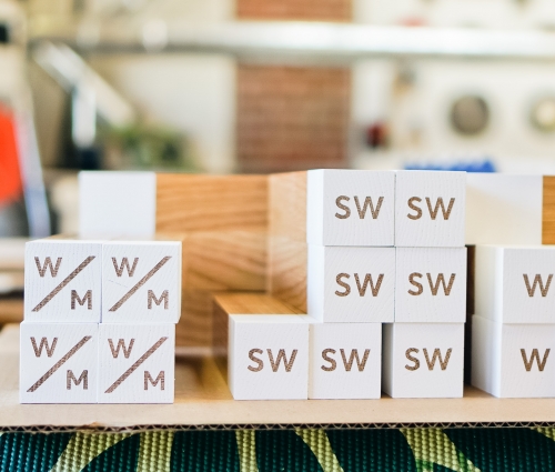 White-painted wood, national park-inspired, overhead wayfinding sign for the office of Slack, a cloud-based set of proprietary team collaboration tools and services.