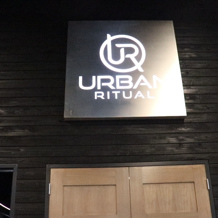 Brushed steel, interior-lit, large square wall sign for Urban Ritual, a fitness studio located in Styles Studios, a boutique fitness studio in Peoria, IL.