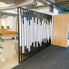 Custom slat wood and metal divider wall for the San Francisco office of Asana, a web and mobile application designed to help teams organize, track, and manage their work.