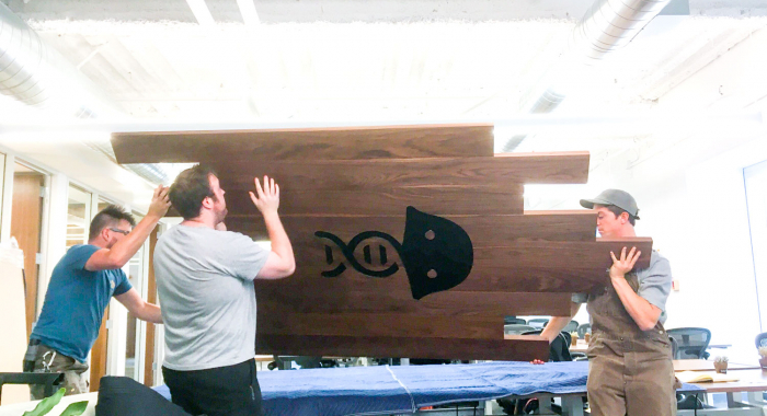 Solid walnut slat sign with engraved jellyfish for the office of Benchling, a San Francisco based company working on a unified platform to accelerate, measure, and forecast R&D from discovery through bioprocessing.