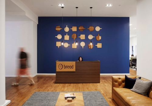 Modern, light wood engraved panel sign for the front lobby desk at Bread, a company that creates point-of-sale financing technologies.