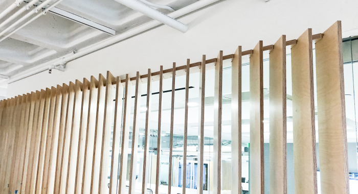 Optical-illusion, multi panel wood sign / privacy screen at the San Francisco office of Compass, a modern real estate platform.