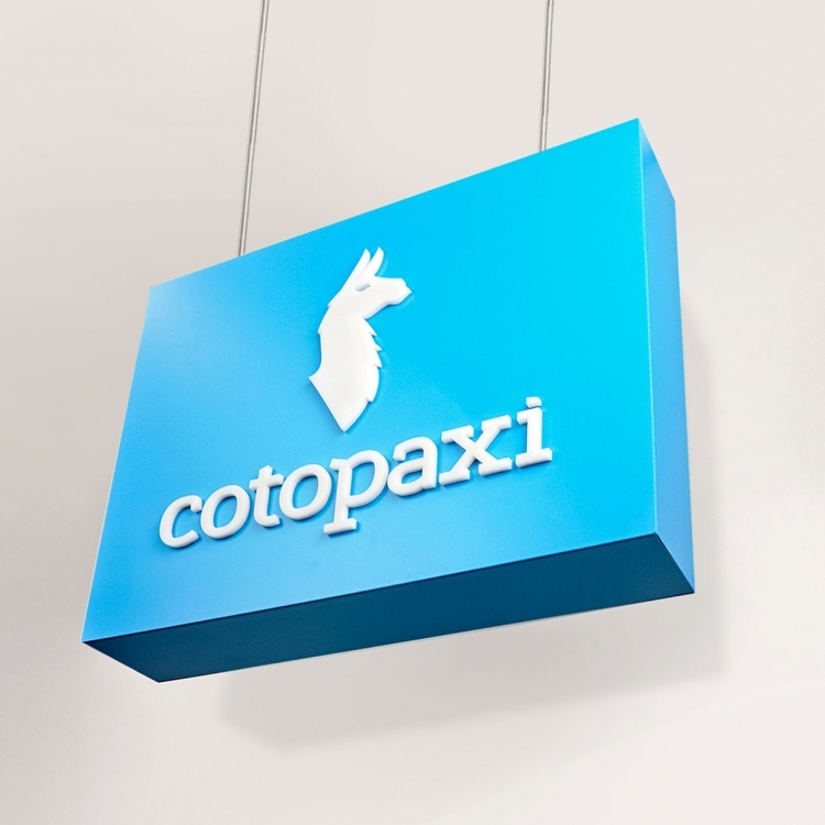 Blue boxed overhead retail sign with white artwork for Cotopaxi, a company that creates innovative outdoor products and experiences.