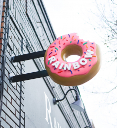 3D, pink-frosted, sculptural, sprinkle donut blade sign for Rainbow Donuts in Berkeley, CA