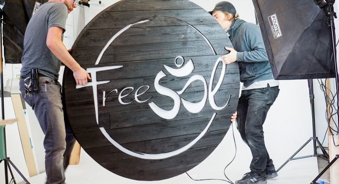 Torched wood, interior-lit, large circular wall sign for FreeSol, a fitness studio located in Styles Studios, a boutique fitness studio in Peoria, IL.