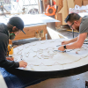 Torched wood, interior-lit, large circular wall sign for FreeSol, a fitness studio located in Styles Studios, a boutique fitness studio in Peoria, IL.