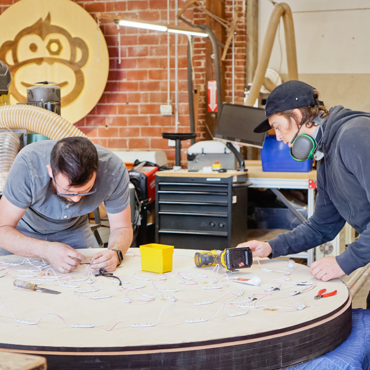 Torched wood, interior-lit, large circular wall sign for FreeSol, a fitness studio located in Styles Studios, a boutique fitness studio in Peoria, IL.