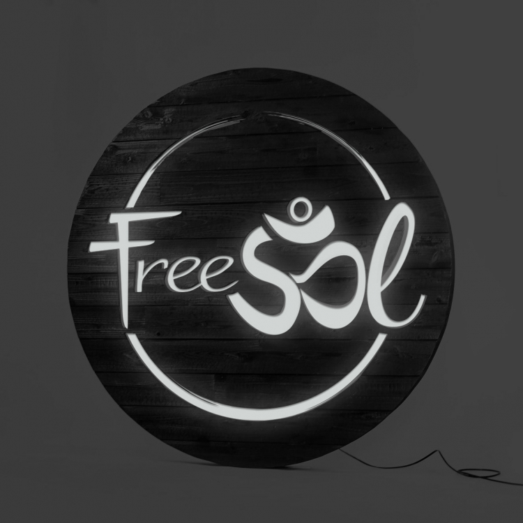 Torched wood, interior-lit, large circular wall sign for FreeSol, a fitness studio located in Styles Studios, a boutique fitness studio in Peoria, IL.