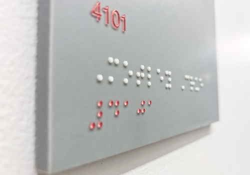 Grey and white meeting room ADA signs with Braille for the San Francisco office of Gong, a conversation intelligence platform for sales.