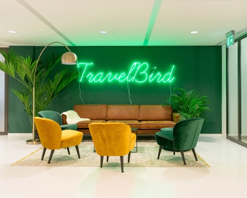 Green neon sign on green painted wall for the lobby of Travelbird, in Amsterdam, Netherlands. (Photo: June Studio Amsterdam)