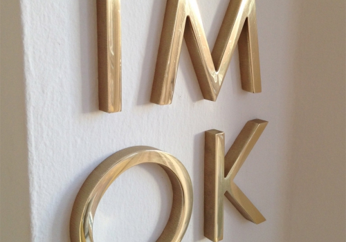 solid brass letters on white wall