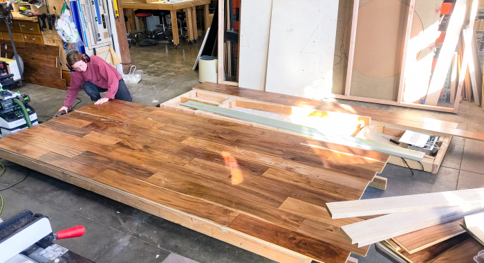 Full wall installation with dark wood and an illuminated, built-in logo for the San Francisco lobby of Indio, a company that simplifies the insurance application process for brokers and their clients.