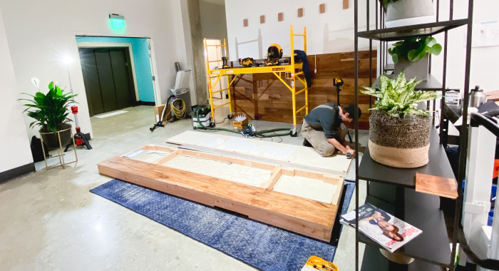 Full wall installation with dark wood and an illuminated, built-in logo for the San Francisco lobby of Indio, a company that simplifies the insurance application process for brokers and their clients.