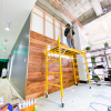 Full wall installation with dark wood and an illuminated, built-in logo for the San Francisco lobby of Indio, a company that simplifies the insurance application process for brokers and their clients.