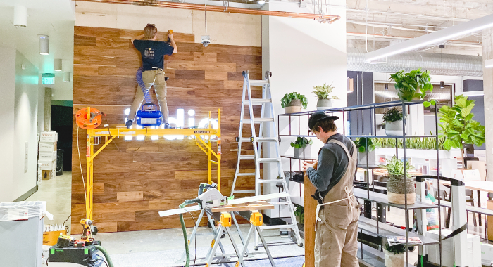 Full wall installation with dark wood and an illuminated, built-in logo for the San Francisco lobby of Indio, a company that simplifies the insurance application process for brokers and their clients.