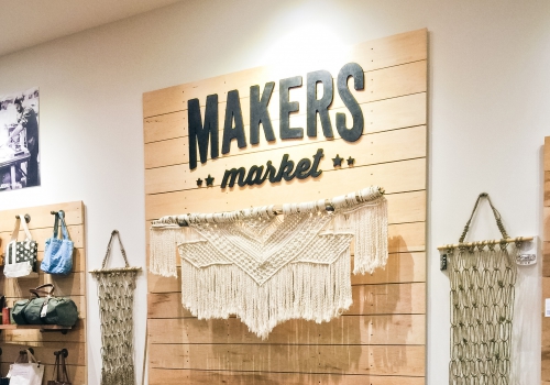 Black and wood interior sign behind cash register for Maker’s Market Black and wood interior sign behind cash register for Maker's Market