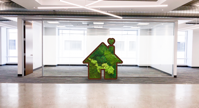 Dark wood house silhouette logo filled with preserved moss art for Zumper, a full-service rental platform.